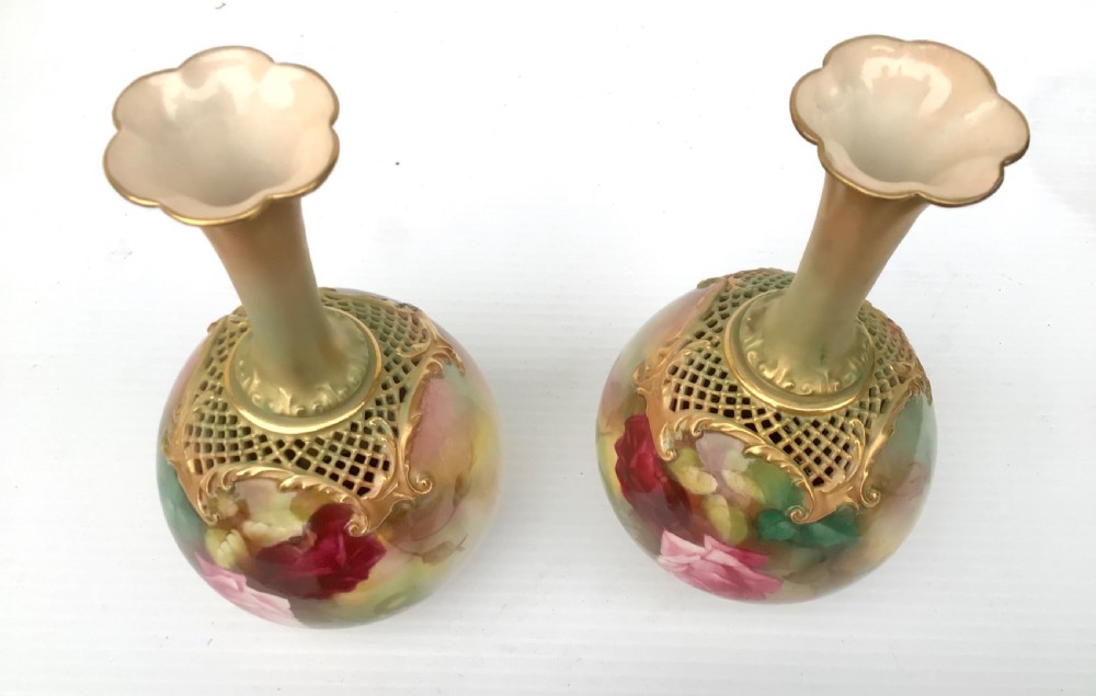 A pair of porcelain vases featuring narrow gilt necks, bulbous bodies hand-painted with pink and crimson roses, and pierced gilt lattice details at the shoulder. View III