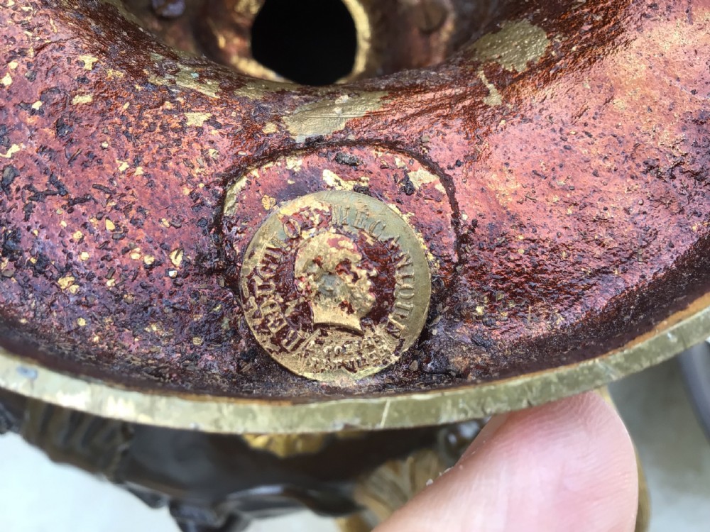 A large gilt and patinated bronze Warwick vase featuring classical relief faces around the central bowl and interwoven vine handles. View V