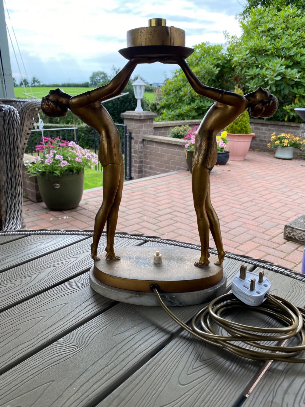 An Art Deco table lamp featuring two gilded female figures supporting a spherical amber glass shade on an oval marble base. View VII
