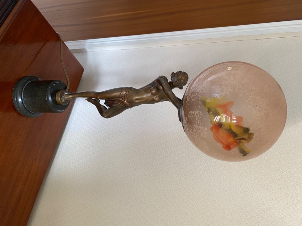 An Art Deco table lamp featuring a bronze dancer figure holding aloft a frosted glass globe shade on a dark marble base. View VI