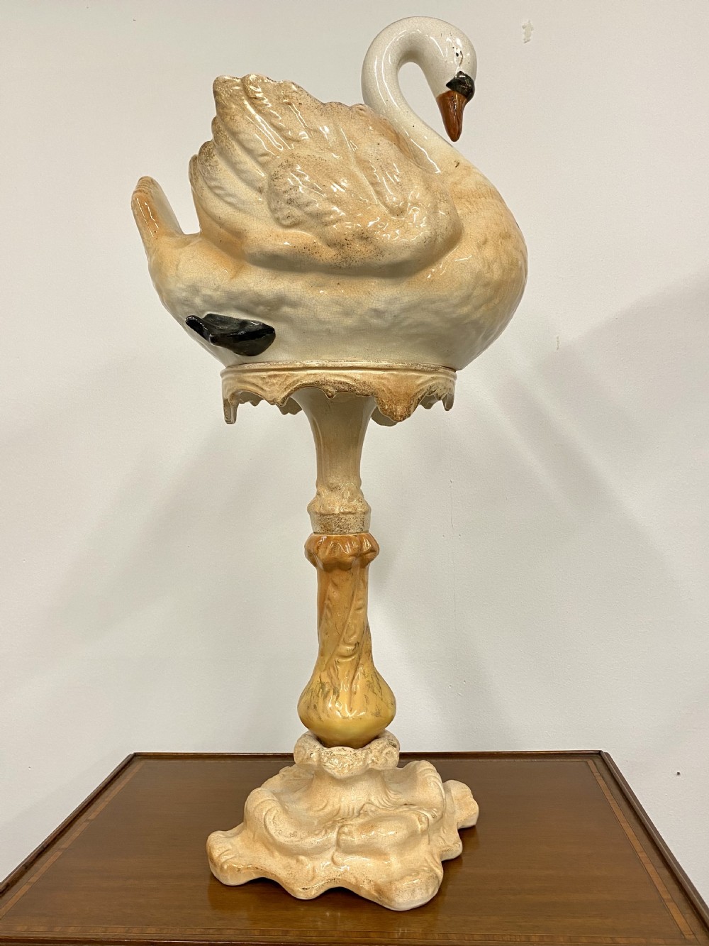 A cream glazed ceramic Victorian jardiniere formed in the shape of a swan resting atop a tall matching ornate pedestal base. View II
