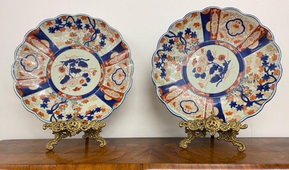 A pair of large Japanese Imari porcelain chargers featuring scalloped rims and hand-painted floral motifs in cobalt blue and iron red. View IV