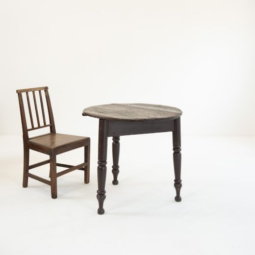 fig 1. A 19th-century circular pine cricket table featuring a dark painted finish and three turned legs.