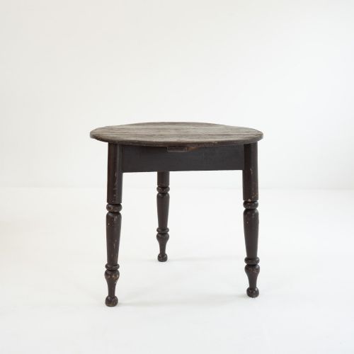 fig 2. A 19th-century circular pine cricket table featuring a dark painted finish and three turned legs.
