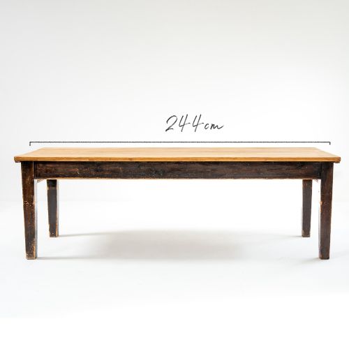 fig 1. An eight-foot long Victorian pine harvest table featuring a natural timber top surface, a distressed black painted apron, and tapered square legs.