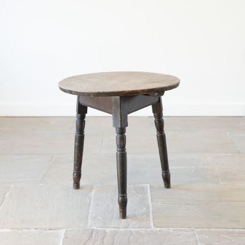 fig 1. An English nineteenth-century dark brown wooden cricket table featuring a circular top and three turned legs.