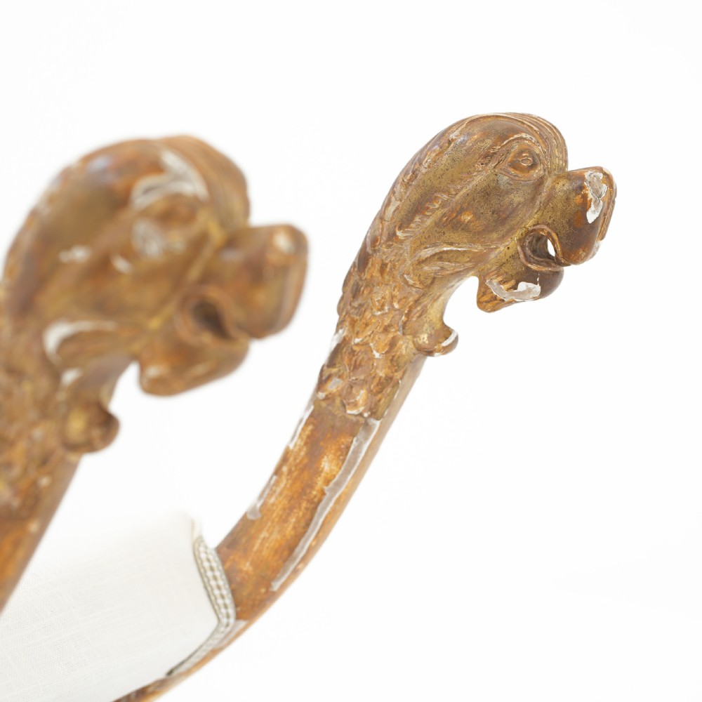 An Italian neoclassical giltwood curule stool with carved lion terminal legs and a pale cream upholstered seat. View IX