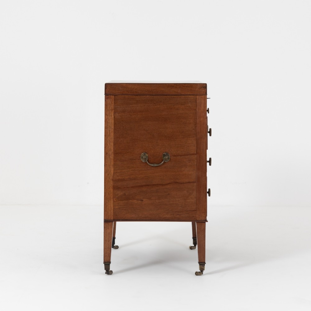 A George III mahogany travelling dressing chest featuring multiple drawer arrangements with circular brass handles, raised on square tapered legs with castors. View II