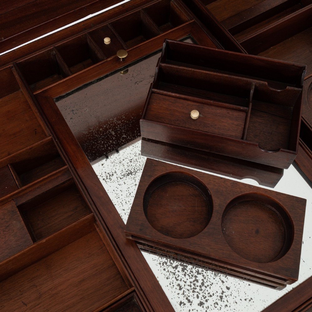 A George III mahogany travelling dressing chest featuring multiple drawer arrangements with circular brass handles, raised on square tapered legs with castors. View VIII