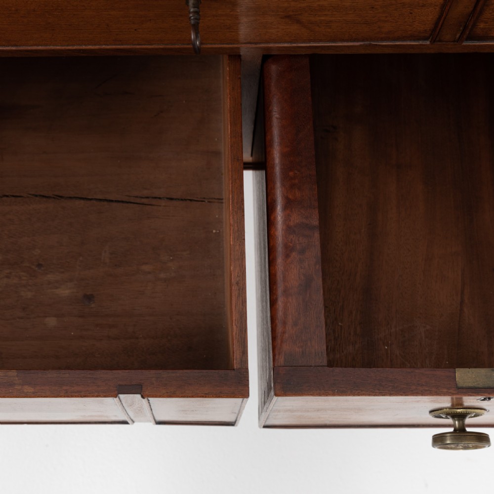 A George III mahogany travelling dressing chest featuring multiple drawer arrangements with circular brass handles, raised on square tapered legs with castors. View IX