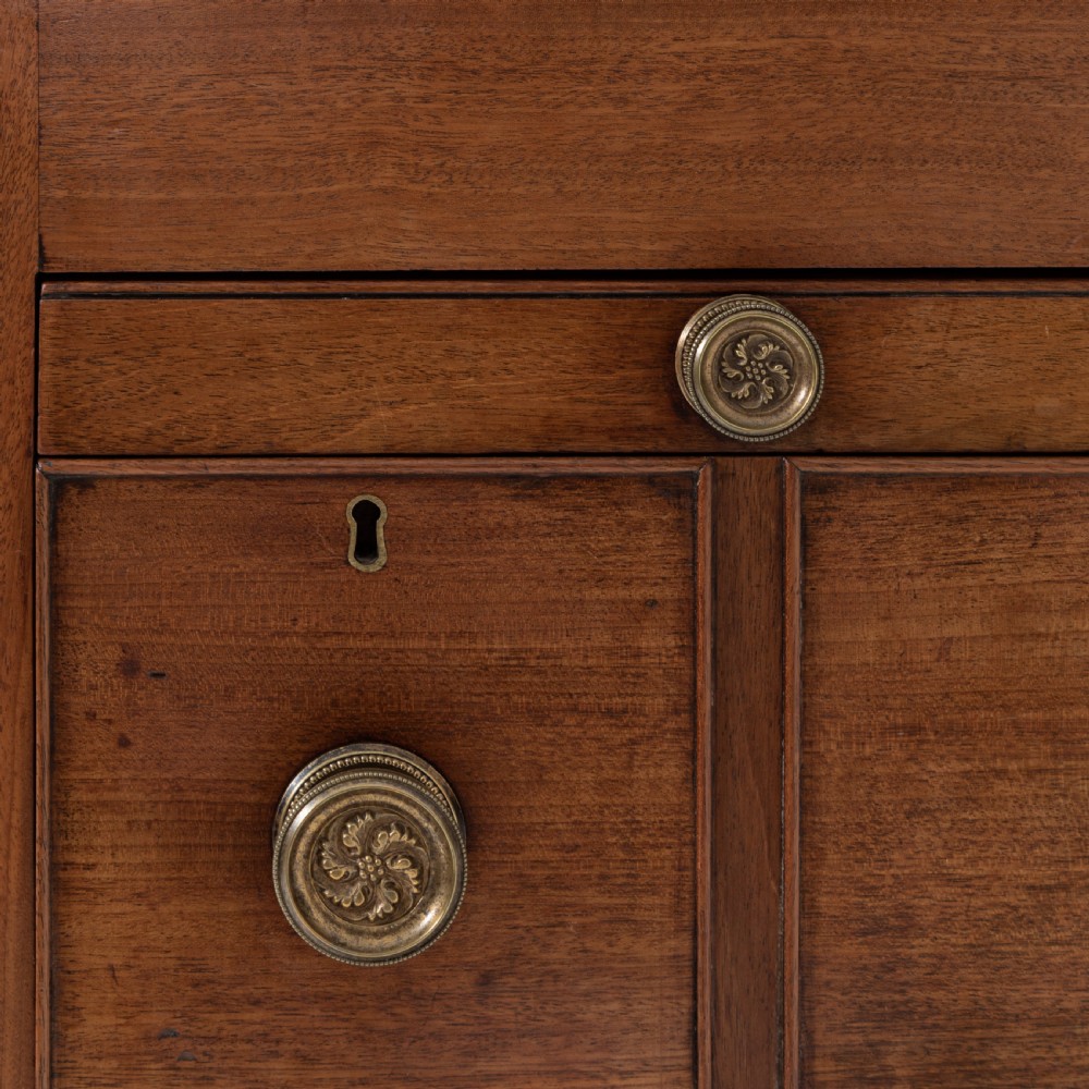 A George III mahogany travelling dressing chest featuring multiple drawer arrangements with circular brass handles, raised on square tapered legs with castors. View XII