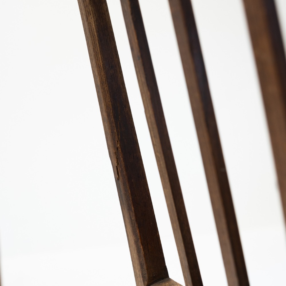 A set of three 18th-century dark wooden farmhouse chairs featuring vertical slat backs, solid wooden seats, and straight legs connected by stretchers. View V