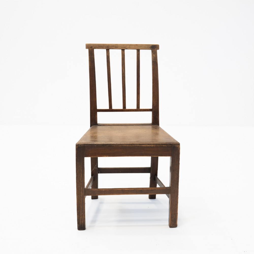 A set of three 18th-century dark wooden farmhouse chairs featuring vertical slat backs, solid wooden seats, and straight legs connected by stretchers. View VII
