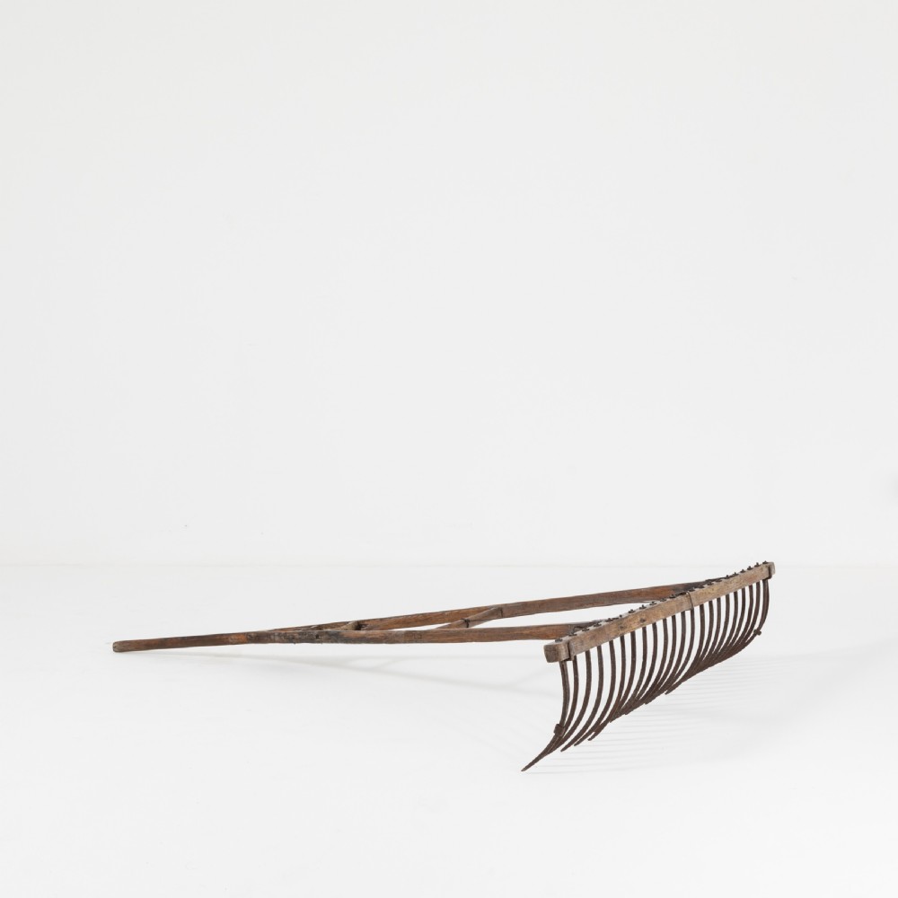 A late nineteenth-century ash hay rake featuring an elongated split-shaft handle and a wide timber head with curved tines. View IV