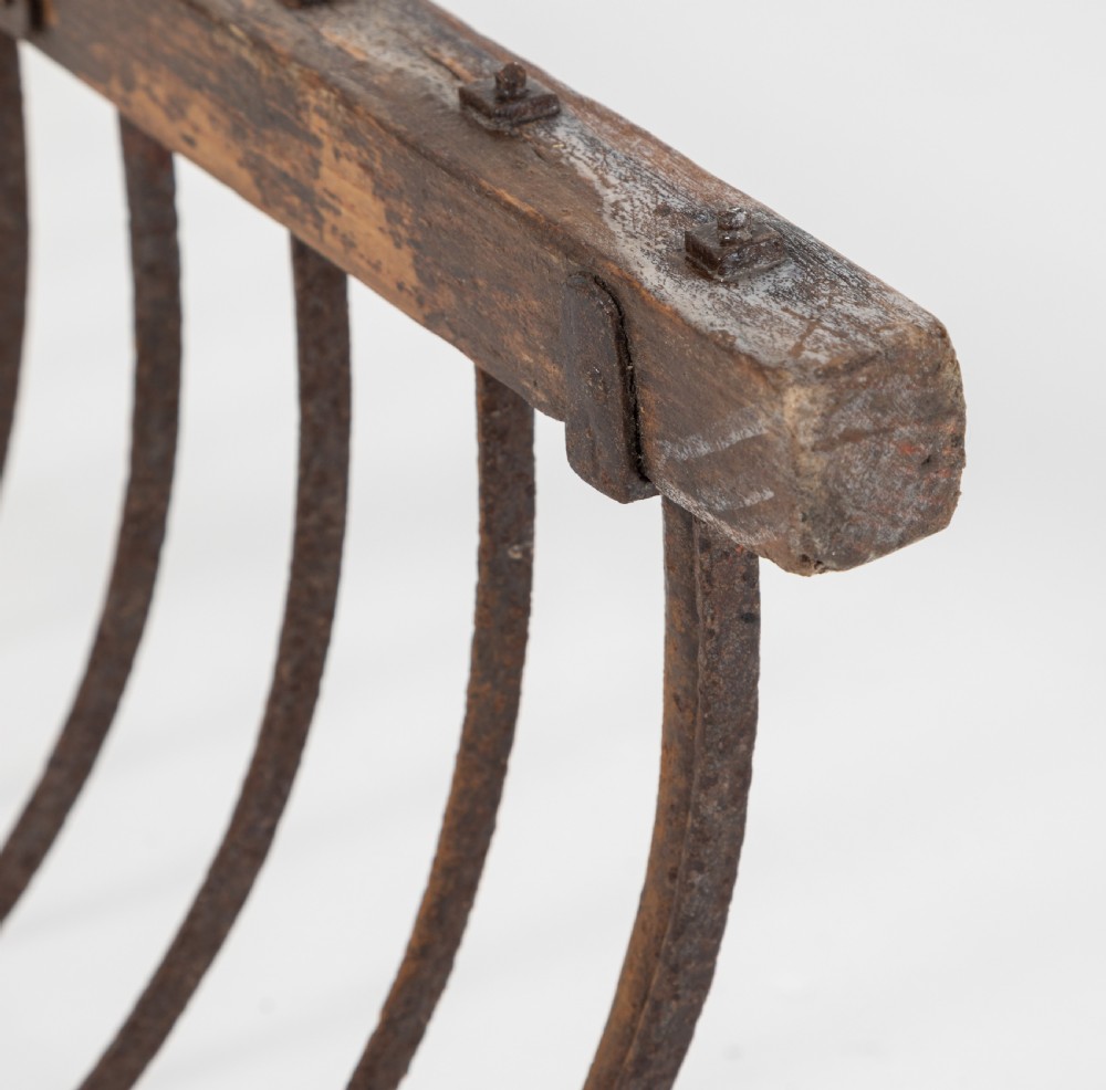 A late nineteenth-century ash hay rake featuring an elongated split-shaft handle and a wide timber head with curved tines. View X