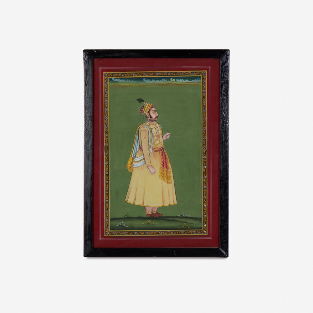 A framed Indian miniature portrait depicting a nobleman in traditional yellow attire standing against a green background with decorative painted borders.