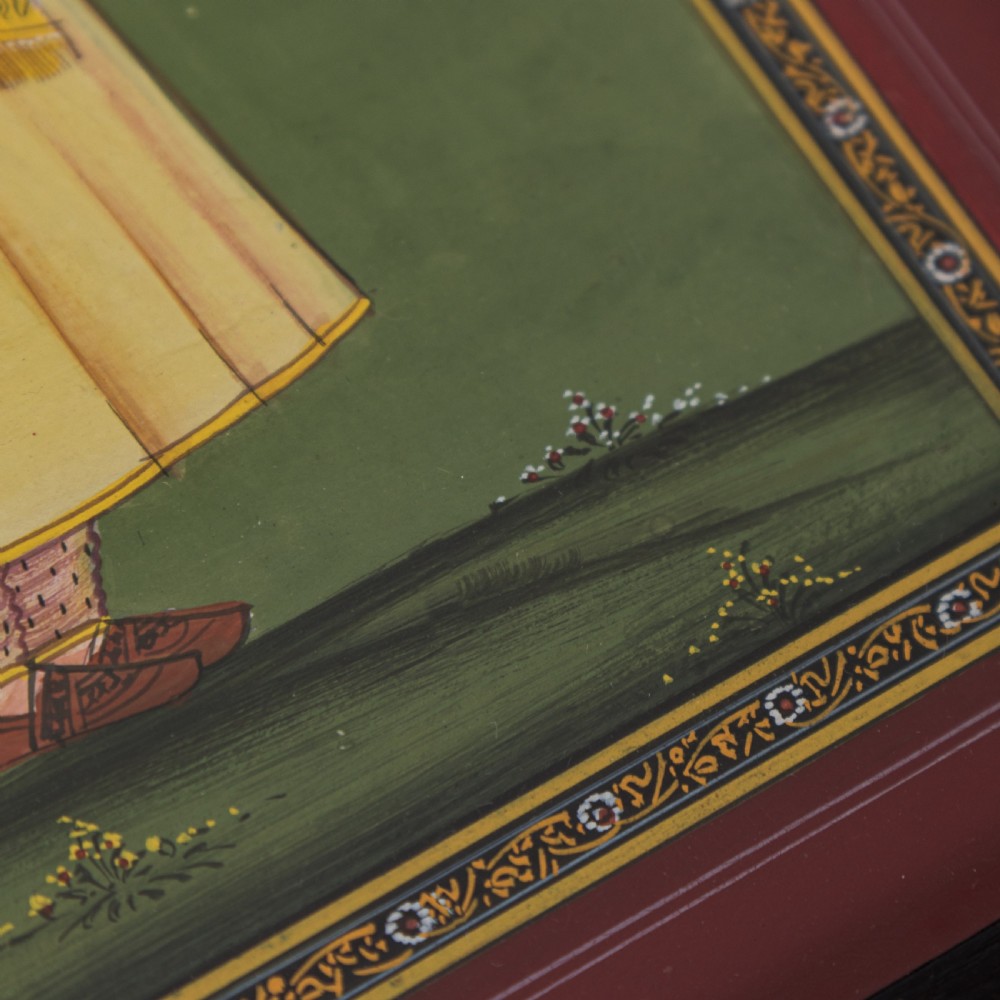 A framed Indian miniature portrait depicting a nobleman in traditional yellow attire standing against a green background with decorative painted borders. View IV