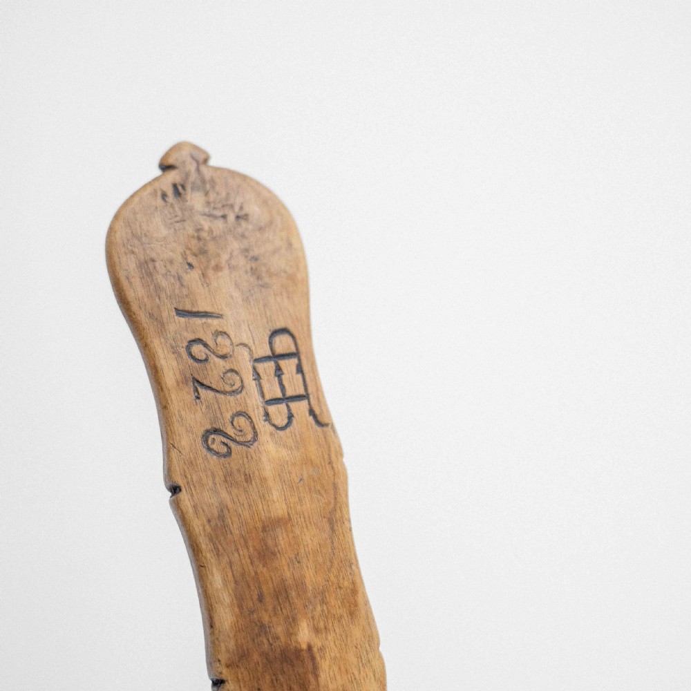 An early twentieth-century hand-carved wooden spoon featuring an oval bowl and an engraved floral pattern along the handle. View IV