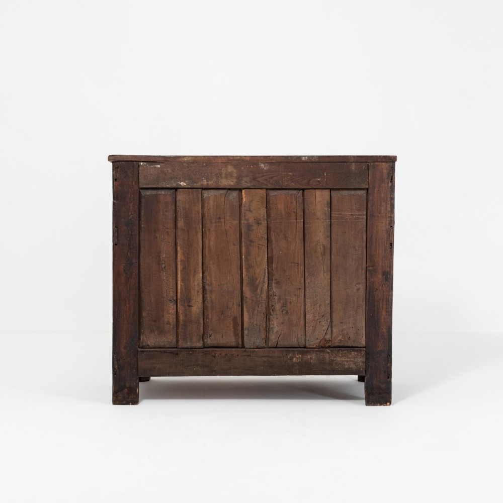 An eighteenth-century Louis XV period dark oak buffet featuring two panelled cabinet doors, three upper drawers, ornate brass hardware, and a shaped apron. View V