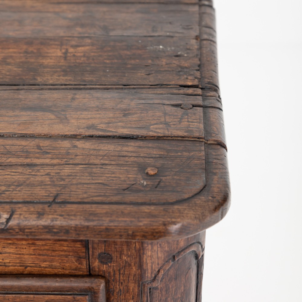 An eighteenth-century Louis XV period dark oak buffet featuring two panelled cabinet doors, three upper drawers, ornate brass hardware, and a shaped apron. View IX