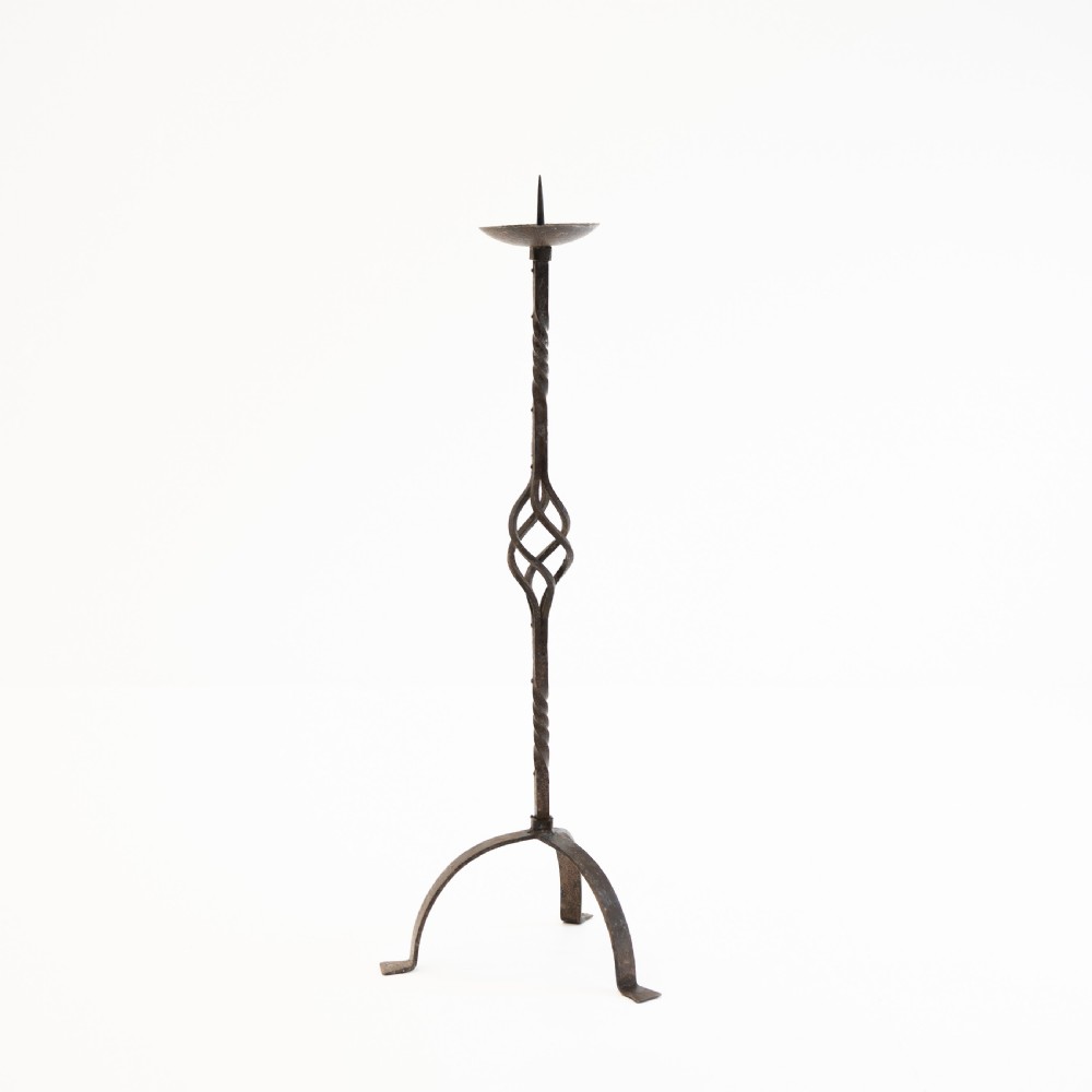 A 19th-century wrought iron pricket candlestick featuring a central spike, twisted stem section, cage knop detail, and an arched tripod base. View II