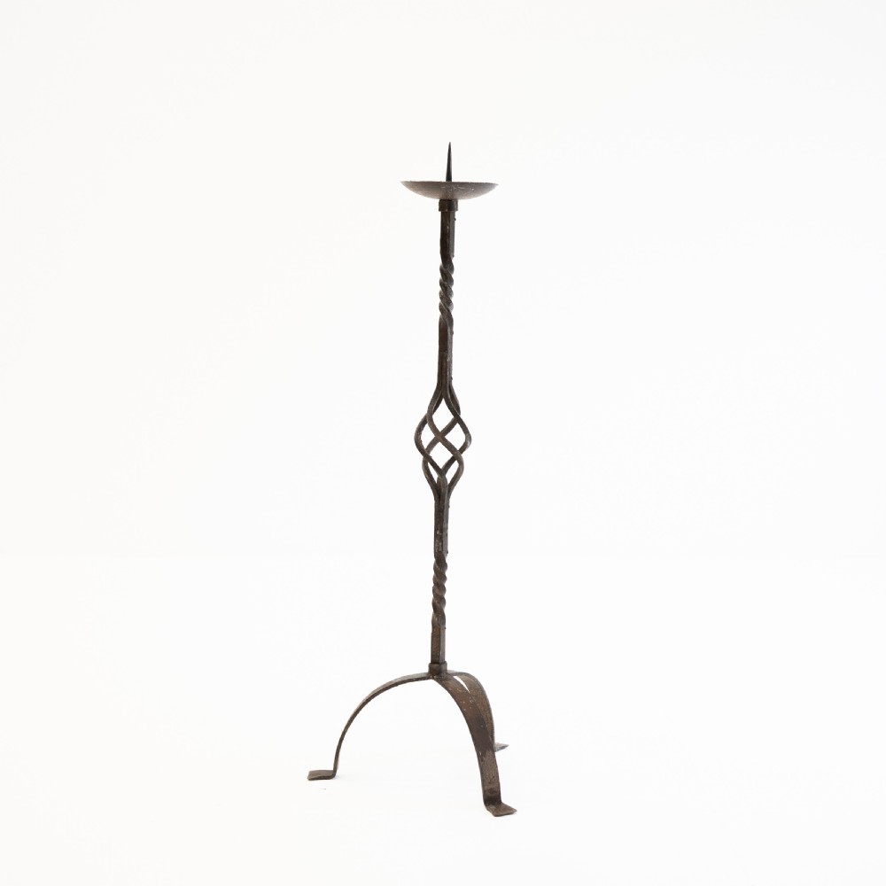 A 19th-century wrought iron pricket candlestick featuring a central spike, twisted stem section, cage knop detail, and an arched tripod base. View III