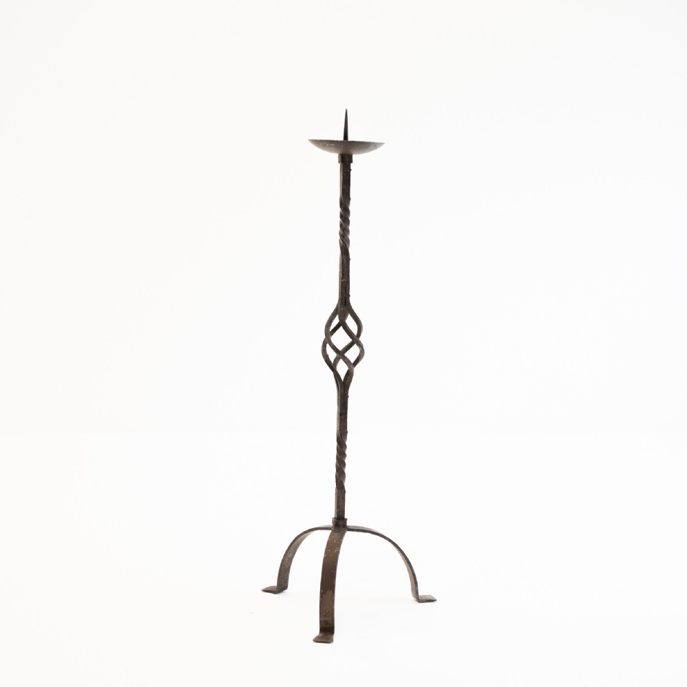 A 19th-century wrought iron pricket candlestick featuring a central spike, twisted stem section, cage knop detail, and an arched tripod base. View IV
