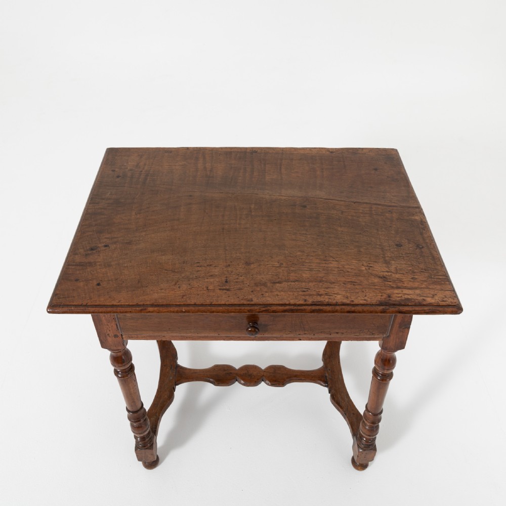 A 17th-century Welsh oak tavern table with turned legs, a single drawer, and an H-stretcher base. View IV