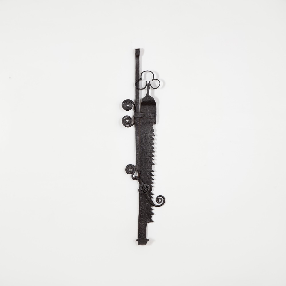 An early 18th-century hand-forged wrought iron adjustable trammel hook featuring a sawtooth ratchet mechanism and decorative scrollwork.