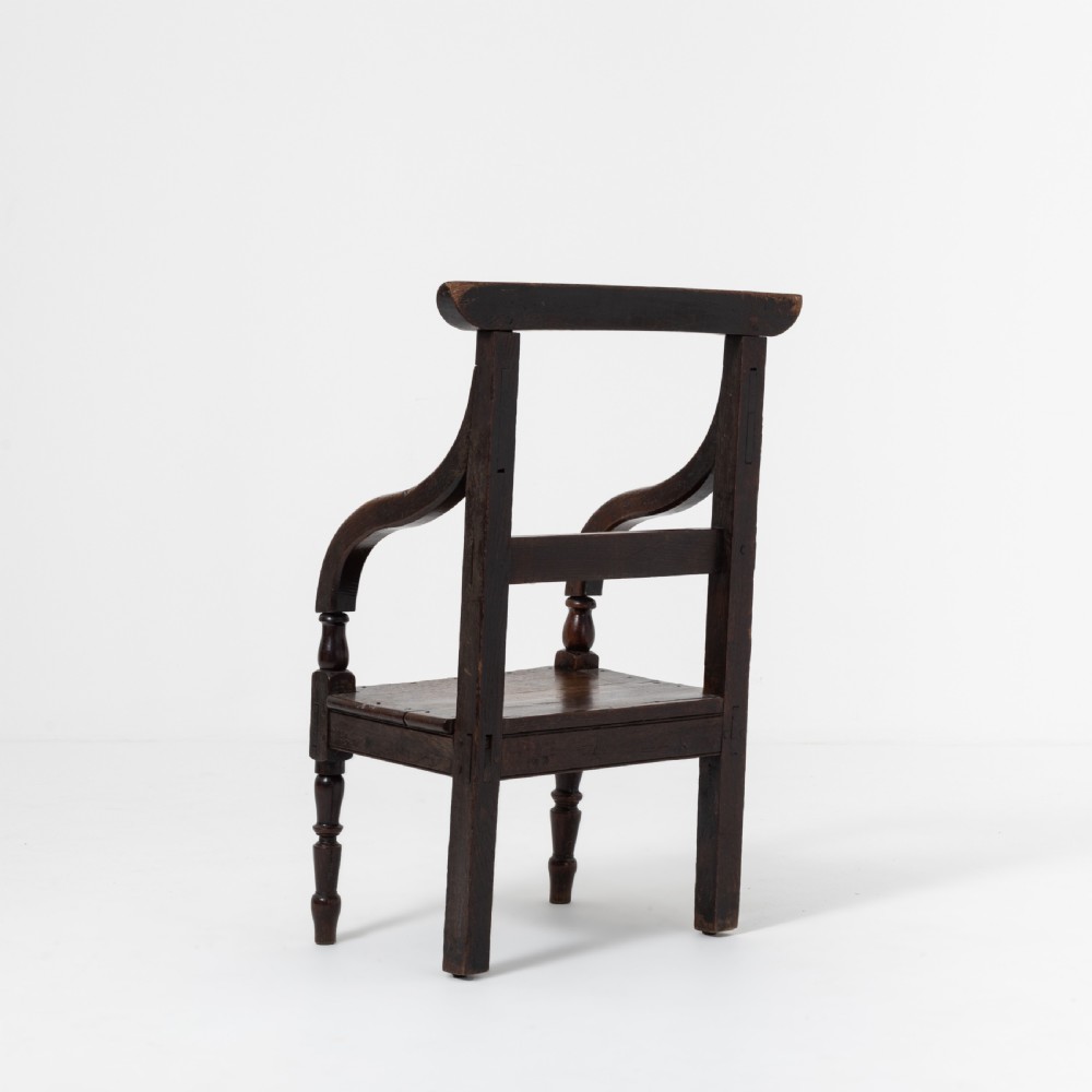 A dark brown 19th-century oak and elm armchair featuring turned front legs, curved arm supports, and a flat top crest rail. View VI