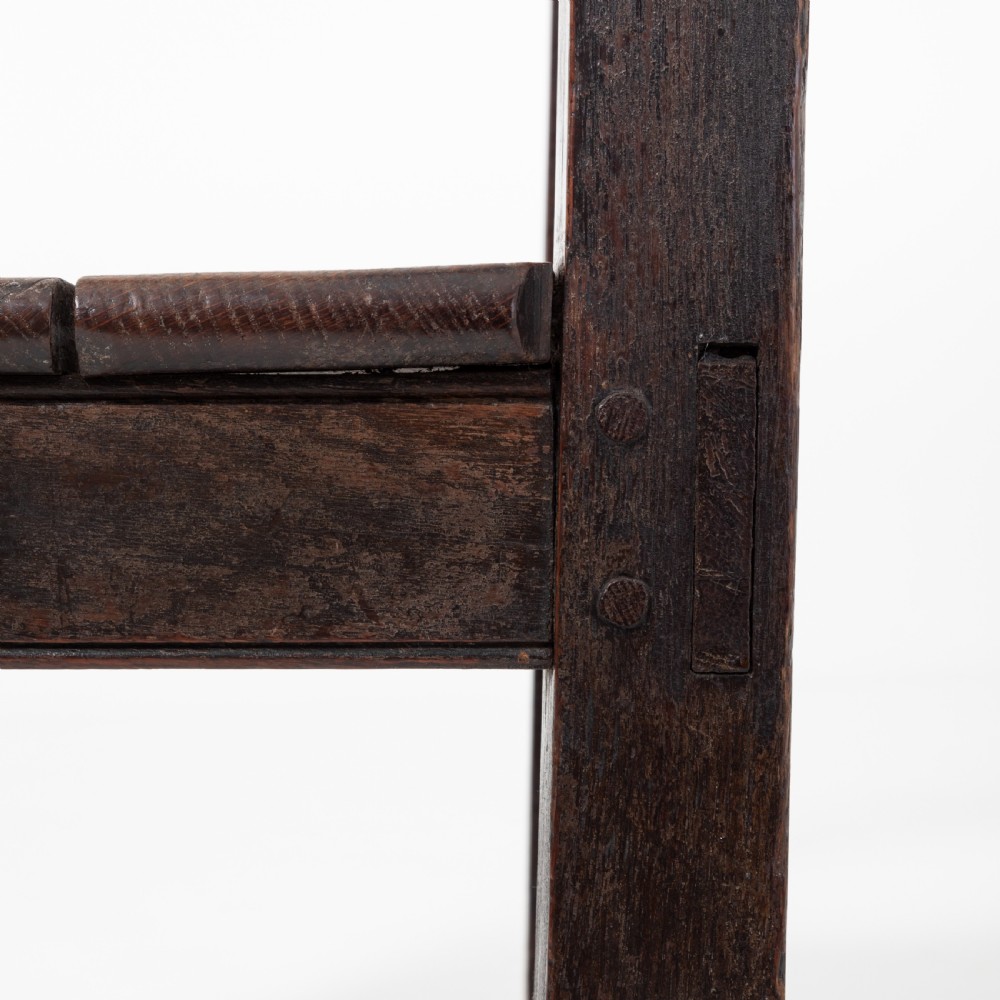 A dark brown 19th-century oak and elm armchair featuring turned front legs, curved arm supports, and a flat top crest rail. View VII