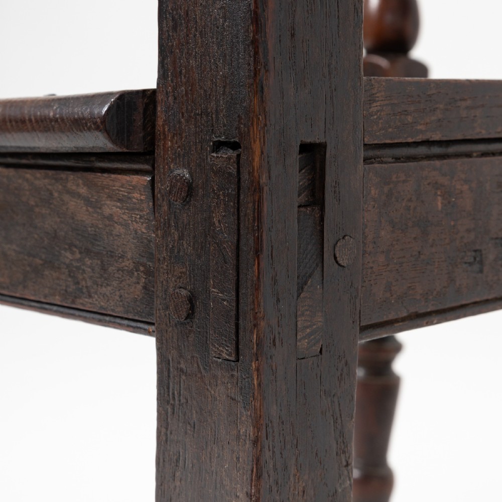 A dark brown 19th-century oak and elm armchair featuring turned front legs, curved arm supports, and a flat top crest rail. View VIII
