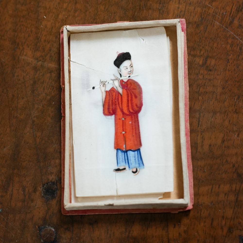 A set of twelve 19th-century Chinese pith paper paintings depicting various figures in traditional Qing dynasty attire playing musical instruments and holding cultural objects. View XI