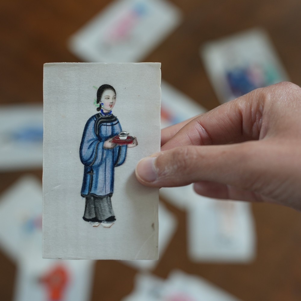 A set of twelve 19th-century Chinese pith paper paintings depicting various figures in traditional Qing dynasty attire playing musical instruments and holding cultural objects. View XV