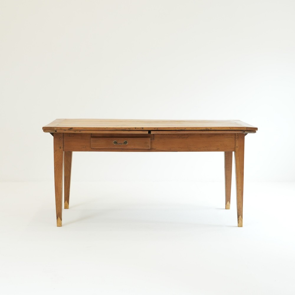 A nineteenth-century French provincial fruitwood dining table featuring square tapered legs, a single frieze drawer, and a draw-leaf extension system. View II