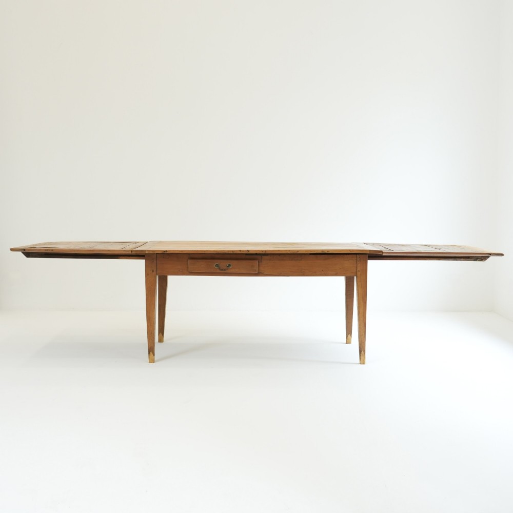 A nineteenth-century French provincial fruitwood dining table featuring square tapered legs, a single frieze drawer, and a draw-leaf extension system. View III