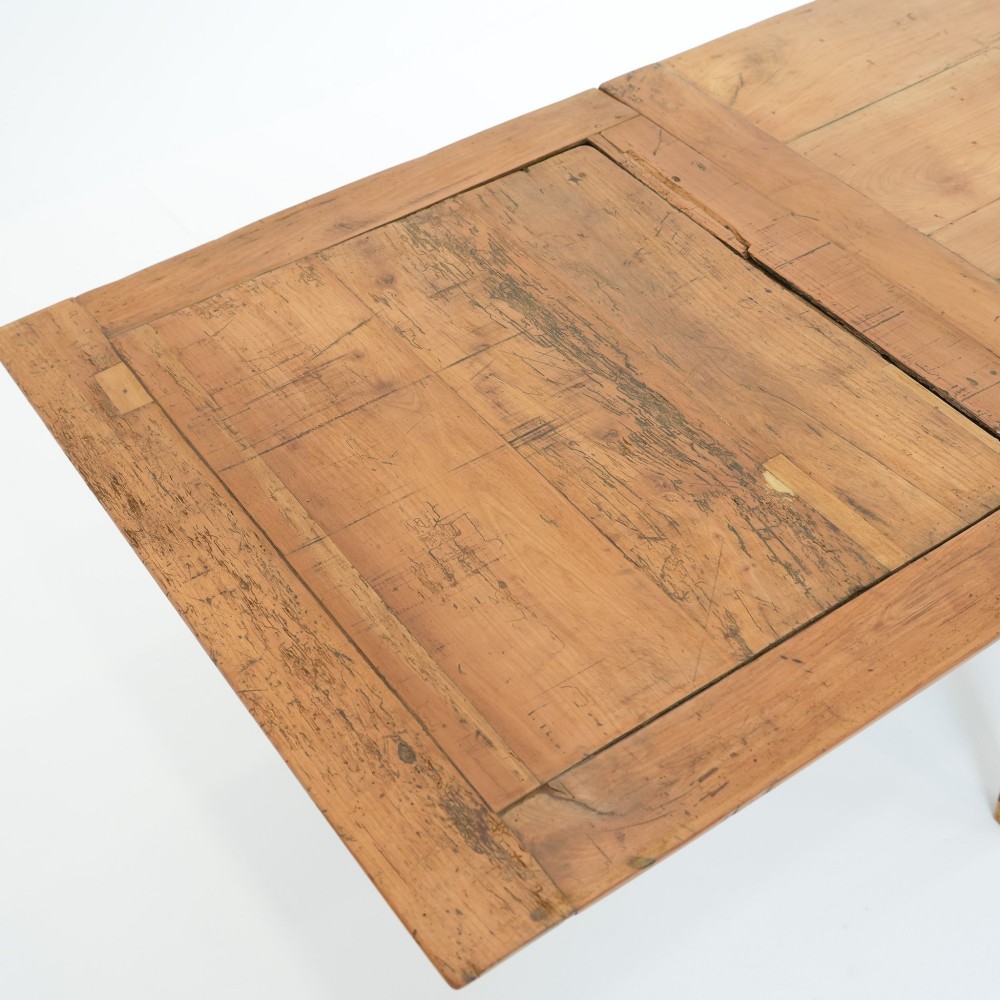 A nineteenth-century French provincial fruitwood dining table featuring square tapered legs, a single frieze drawer, and a draw-leaf extension system. View IV
