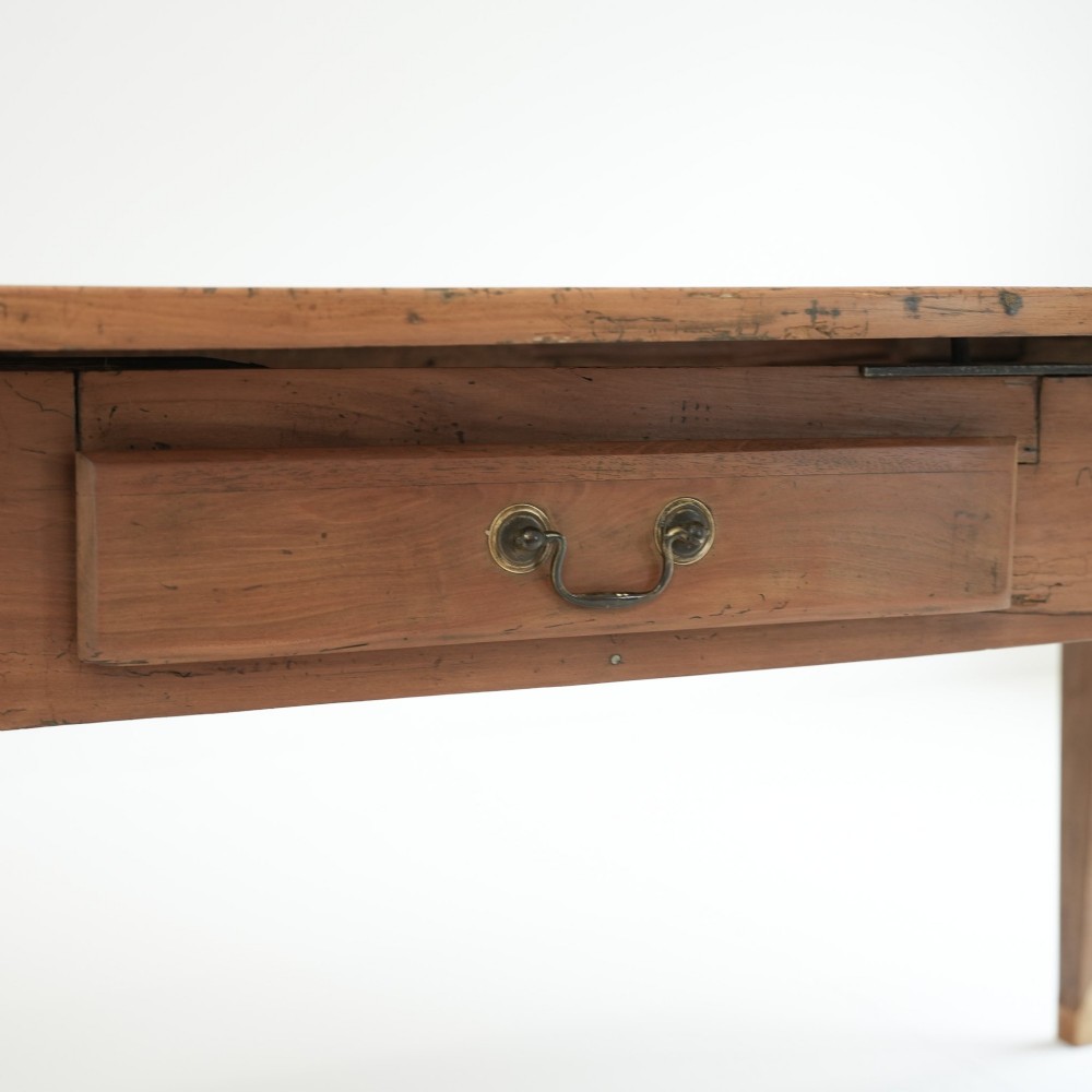 A nineteenth-century French provincial fruitwood dining table featuring square tapered legs, a single frieze drawer, and a draw-leaf extension system. View VIII