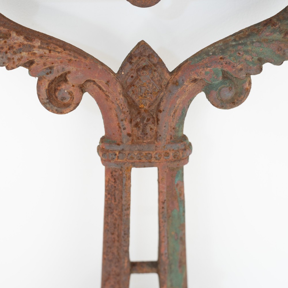 A pair of ornate Victorian cast iron table bases featuring openwork scrollwork and a rusted finish with traces of original green paint. View III
