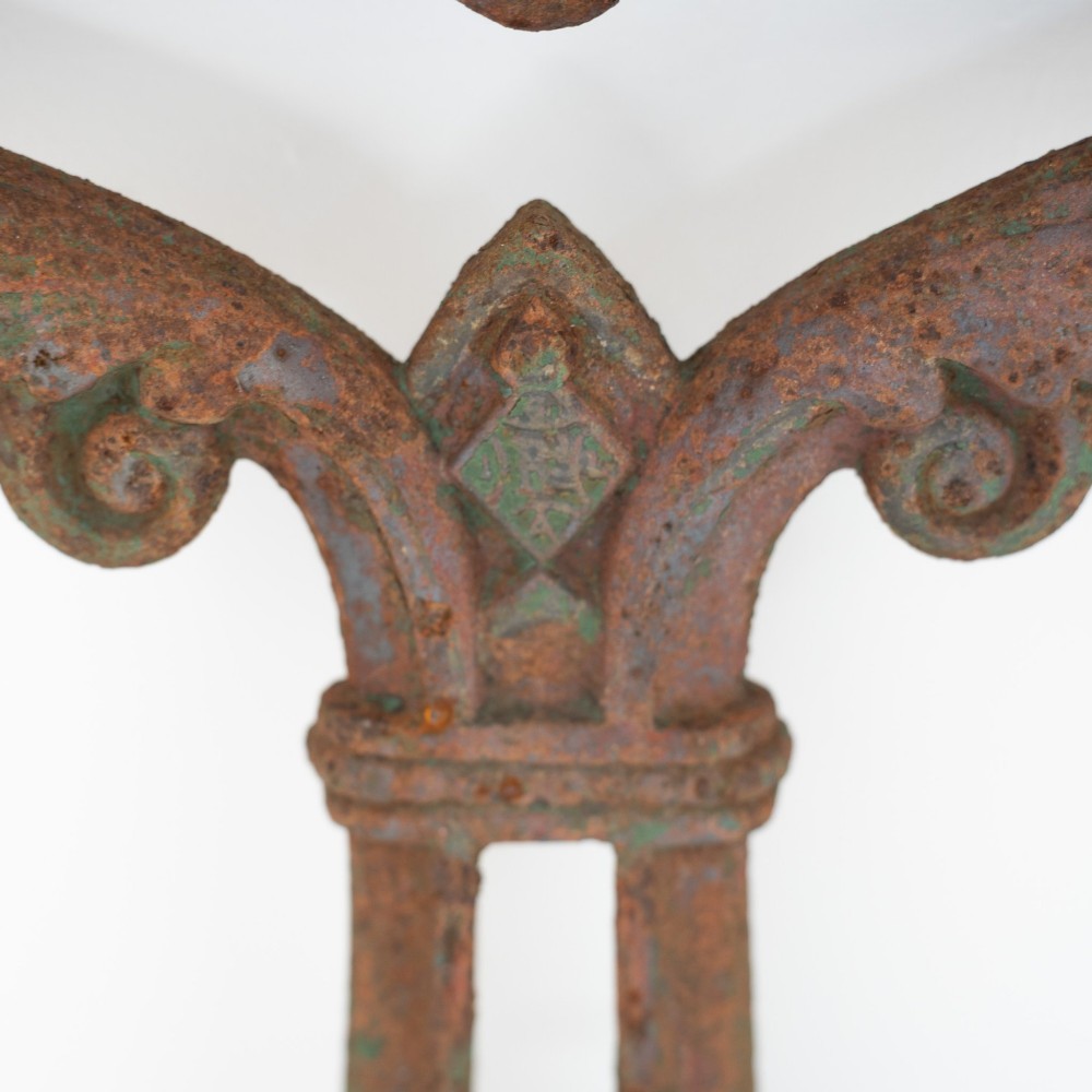 A pair of ornate Victorian cast iron table bases featuring openwork scrollwork and a rusted finish with traces of original green paint. View IV