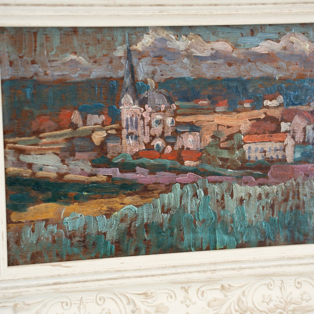 An oil painting on wooden panel depicting a European townscape with a central church spire, set within an off-white carved decorative frame. View IV