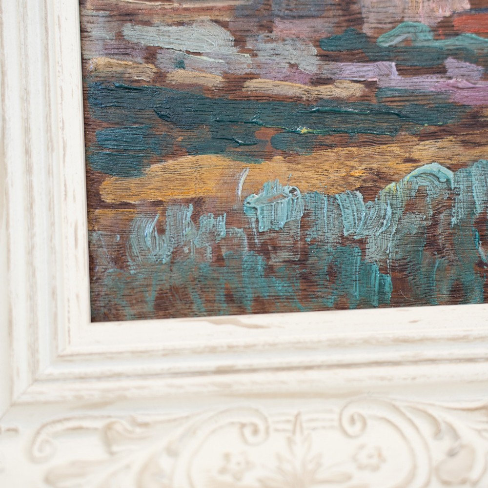 An oil painting on wooden panel depicting a European townscape with a central church spire, set within an off-white carved decorative frame. View V