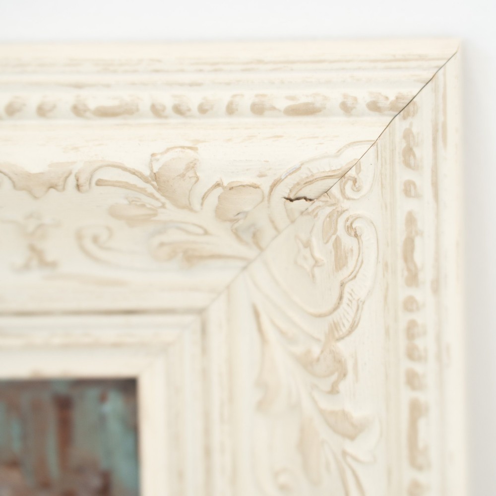 An oil painting on wooden panel depicting a European townscape with a central church spire, set within an off-white carved decorative frame. View IX