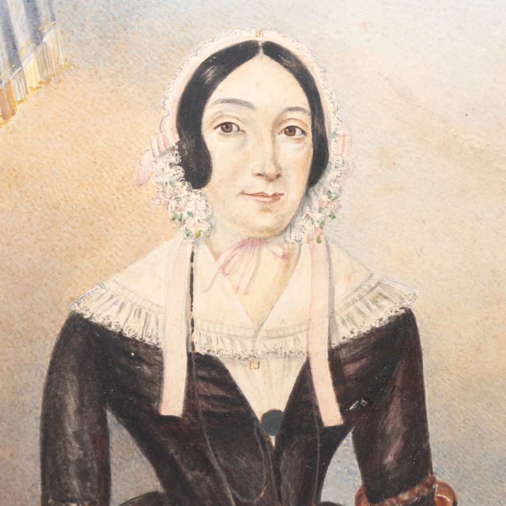 A pair of mid-19th century framed folk art portraits depicting a seated woman and man in period clothing. View VI