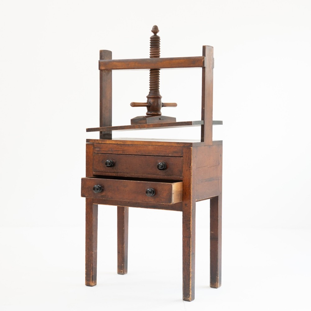 A Victorian mahogany and pine linen press featuring a central wooden screw mechanism over two small drawers with turned black knobs and four square legs. View V