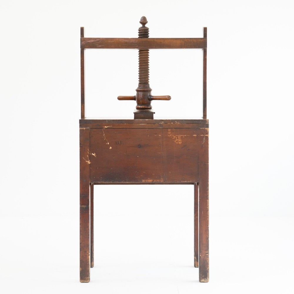 A Victorian mahogany and pine linen press featuring a central wooden screw mechanism over two small drawers with turned black knobs and four square legs. View VII