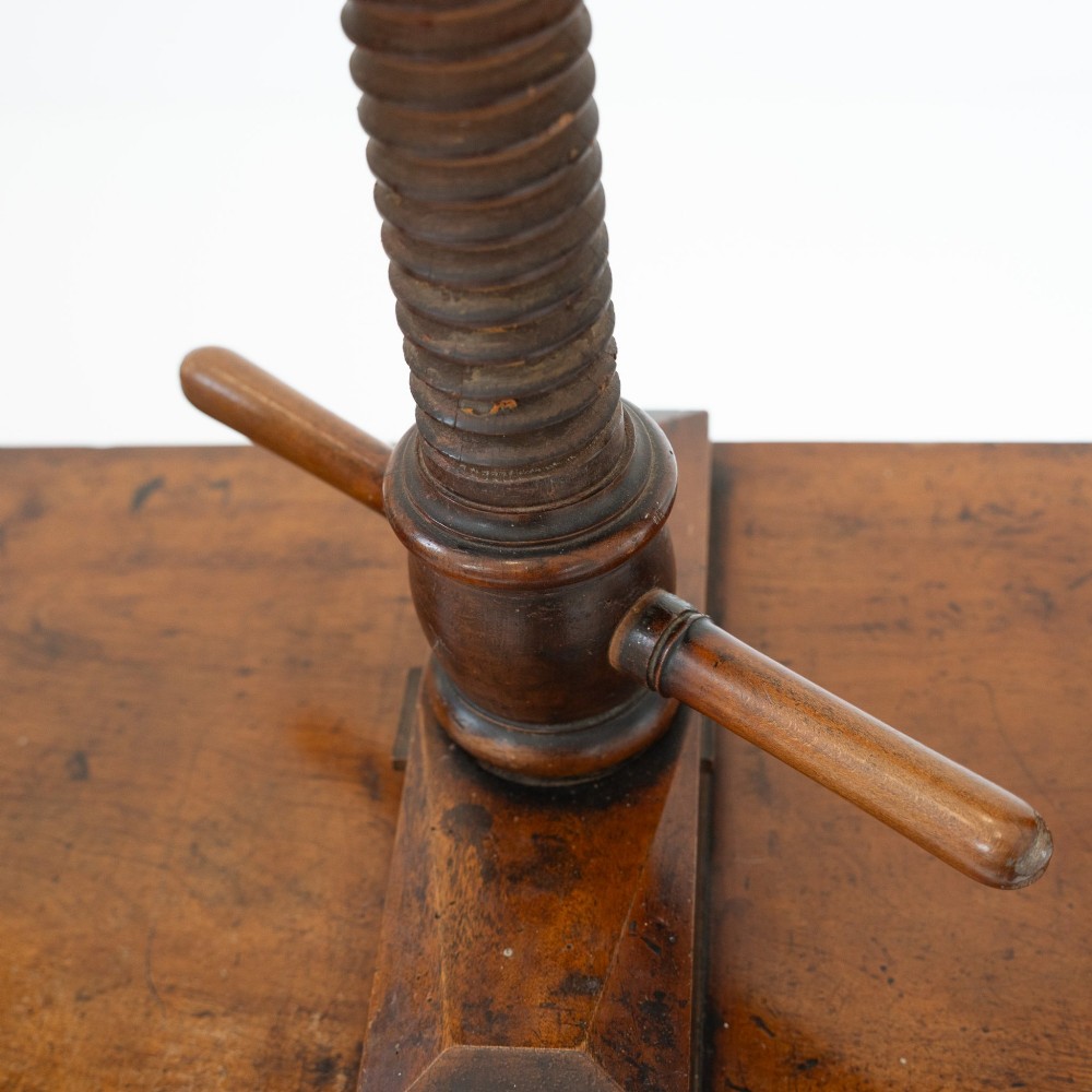 A Victorian mahogany and pine linen press featuring a central wooden screw mechanism over two small drawers with turned black knobs and four square legs. View XI