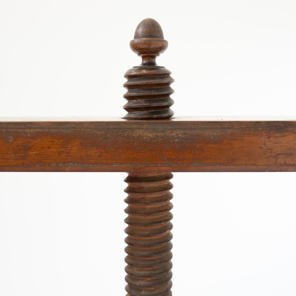 A Victorian mahogany and pine linen press featuring a central wooden screw mechanism over two small drawers with turned black knobs and four square legs. View XIV