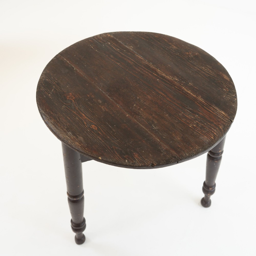A 19th-century circular pine cricket table featuring a dark painted finish and three turned legs. View VII