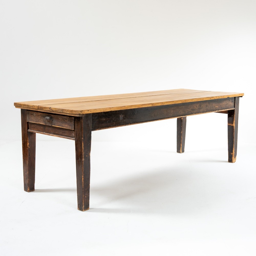 An eight-foot long Victorian pine harvest table featuring a natural timber top surface, a distressed black painted apron, and tapered square legs. View III